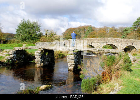 Die alten Klöppel Brücke überquert den East Dart River in der Ortschaft Postbridge auf Dartmoor, Devon, UK Stockfoto