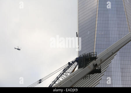 New York City, NY, USA. 12. November 2014. Zwei Fenster-Scheiben, die von der Seite des World Trade Centers blieben baumelt, nachdem ihre Gerüste eine 68 Stockwerke hoch Fehlfunktion. Feuerwehrmänner brachen ein Fenster im 68. Stock, später die beiden Männer aus dem Gerüst zu retten. Der Arbeitnehmer hatte das Gebäude gegangen, wenn eines der motorisierten Kabel unterstützen das Gerüst eingerastet oder kam locker. One World Trade wiedereröffnet letzte Woche mit neuen Mietern nur Umzug in das Gebäude, das die Twin Towers ersetzt. Bildnachweis: Krista Kennell/ZUMA Draht/Alamy Live-Nachrichten Stockfoto