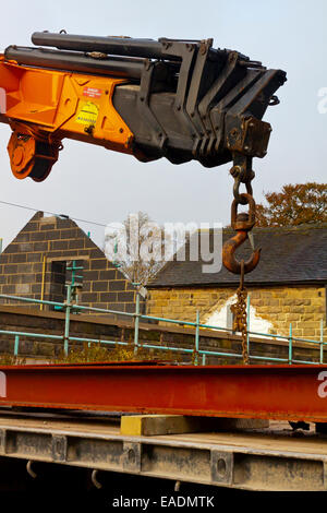 Ausfahrbare Kran verwendet wird, um Materialien von der Rückseite eines LKW auf einer Baustelle zu heben Stockfoto