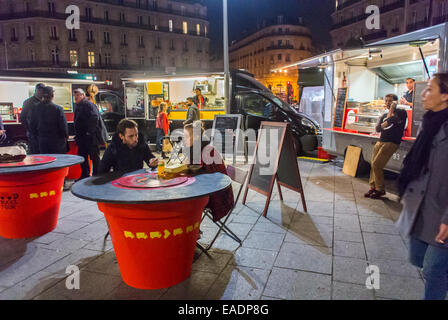 Paris, Frankreich, Menschen, die Mahlzeiten teilen, an Tischen im Freien, französische Street Food Trucks außerhalb des Verkäufers, nachts, Essen im Food Truck Stockfoto