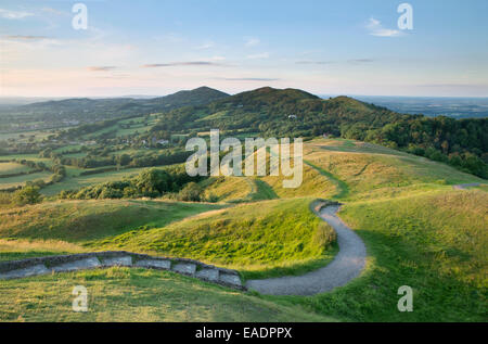 Die Stadtmauer der historischen Wallburg der britischen Lager, Herefordshire Beacon, sind mit dem starken Licht aus den Sonnenuntergang beleuchtet Stockfoto