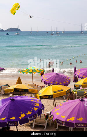 Paragliding und Sonnenschirme am Strand von Patong, Phuket, Thailand Stockfoto