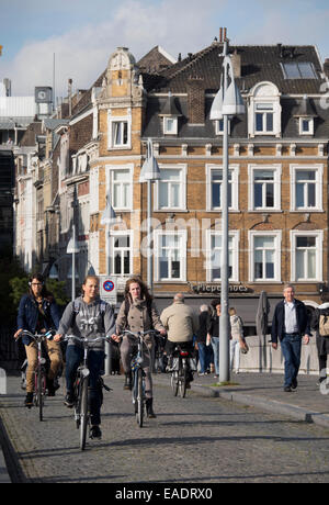 Menschen auf Fahrrädern auf einer gepflasterten Straße in Maastricht, Niederlande, Europa Stockfoto