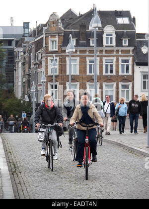 Menschen auf Fahrrädern auf einer gepflasterten Straße in Maastricht, Niederlande, Europa Stockfoto