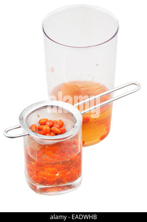 Vorbereitung der Goji-Beere Tinktur - Topf und Glas mit Goji-Beeren-Infusion isoliert auf weißem Hintergrund Stockfoto