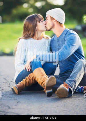 Glückliche junge Paare, die Spaß im Freien. Romantisches Paar küssen in der Liebe auf der Landstraße. Stockfoto