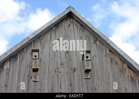 Zwei hölzerne Vogelhäuschen befestigt an der Wand des alten hölzernen Scheune Stockfoto