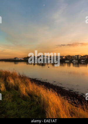 Sonnenuntergang über der Crouch Mündung Darstellung Hullbridge am fernen Ufer reflektieren ein ruhiger Fluss mit dem Mond sichtbar. Stockfoto