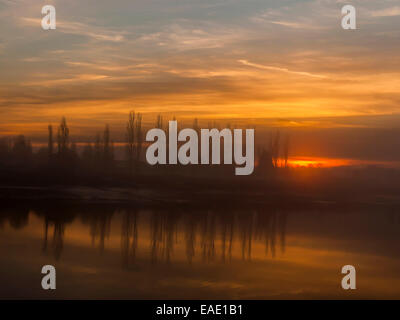 Sonnenuntergang über der Crouch-Mündung, die Darstellung einer Reihe von Pappeln entlang des Flussufers reflektieren ein ruhiger Fluss mit dem Himmel leuchten Stockfoto