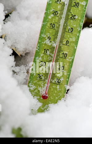 Thermometer in schneebedeckten Feld markiert Temperaturen unter dem Gefrierpunkt Stockfoto