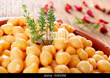 Nahaufnahme von einem Steingut-Schüssel mit gekochten Kichererbsen auf einem rustikalen Holztisch Stockfoto