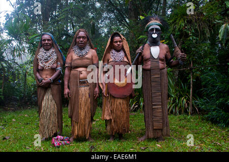 Stammesführer und drei Frauen tragen traditionelle Kleider, Highlands Region, Papua New Guinea Stockfoto