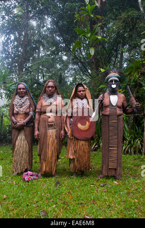 Stammesführer und drei Frauen tragen traditionelle Kleider, Highlands Region, Papua New Guinea Stockfoto