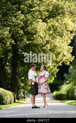 Mann in Lederhose und eine Frau trägt ein Dirndl im Schlosspark Ambras Burg Gärten, Innsbruck, Tirol, Österreich Stockfoto