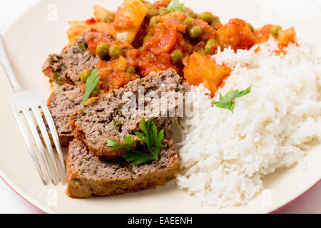 Hausgemachter Hackbraten in Tomatensauce mit Erbsen und Kartoffeln gebacken. Stockfoto