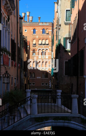 Brücke über einen schmalen dunklen Kanal in Venedig, Italien. Stockfoto