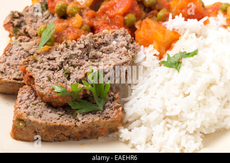 Hausgemachter Hackbraten in Tomatensauce mit Erbsen und Kartoffeln gebacken. Stockfoto