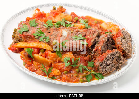 Hausgemachter Hackbraten in Tomatensauce mit Erbsen und Kartoffeln gebacken. Stockfoto