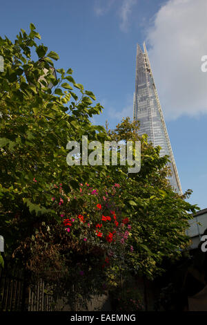 Die Scherbe erhebt sich über Blumen und Bäume in Southwark, London, UK. Auch bezeichnet als der Shard of Glass. Stockfoto