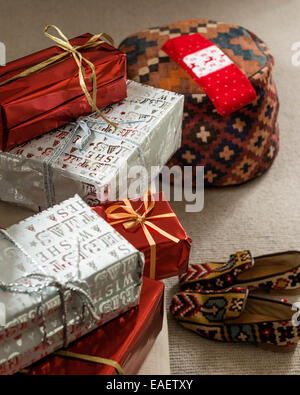 Verpackte Geschenke, Gobelin-Hausschuhe aus Pickett und Kelim Pouf Stockfoto