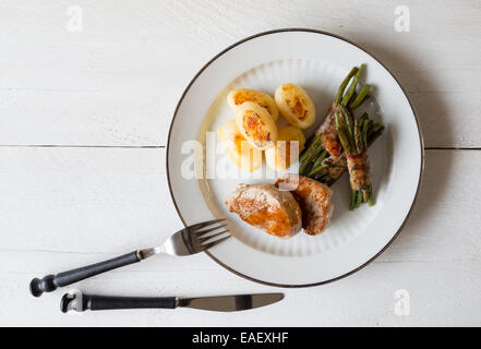 Schweinsmedaillons mit Kartoffeln und Bohnen im Speckmantel Stockfoto