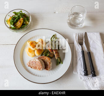 Schweinsmedaillons mit Kartoffeln und Bohnen im Speckmantel Stockfoto