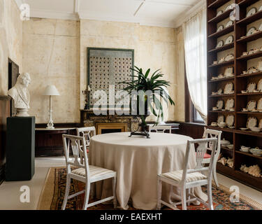 Alfred Meakin englischen China auf Deckenhöhe Regale im Speisesaal mit weißen amerikanischen 19C Stühle, Frank Faulkner Kunstwerk und Stockfoto