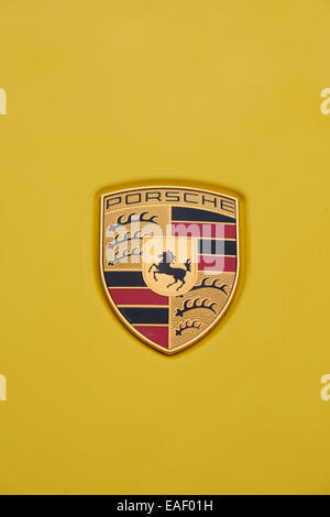 Porsche Logo Abzeichen auf die Karosserie eines gelben Porsche Autos Stockfoto