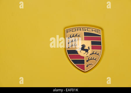 Porsche Logo Abzeichen auf die Karosserie eines gelben Porsche Autos Stockfoto