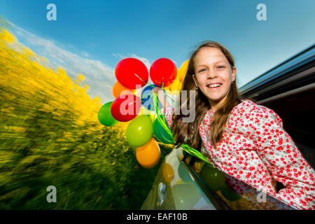 Kleines Mädchen mit Luftballons lachen Stockfoto