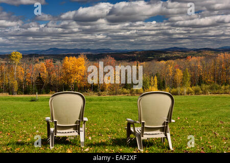 Zwei Liegestühlen am Green Bay mit Blick auf Peacham und Barnet Hügel Vermont USA mit Herbstfarben und Wolken am blauen Himmel Stockfoto