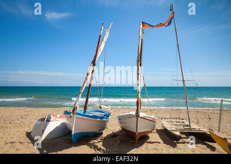 Kleine Segelboote lag auf den Sandstrand von Calafell Stadt, Küste des Mittelmeeres, Katalonien, Spanien Stockfoto