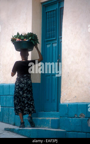 Maya-Mädchen trägt einen Korb mit Zutaten auf dem Kopf in der Stadt Flores, El Petén, Guatemala Stockfoto