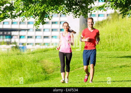 Fitness-Freunde, die zusammen durch den Park laufen Stockfoto