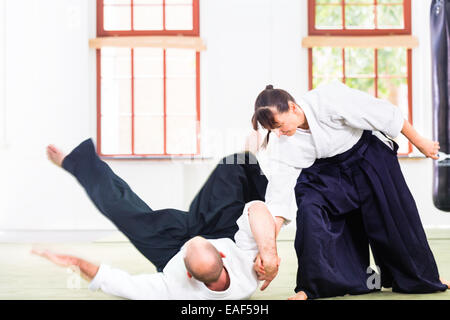 Mann und Frau kämpfen an der Aikido-Training in der Kampfkunst-Schule Stockfoto