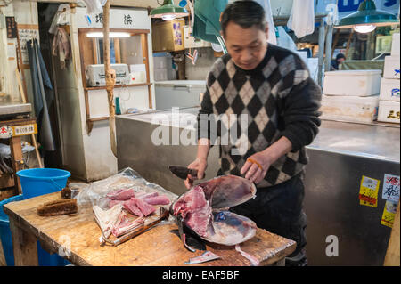 Mann zerschneiden Thunfisch Kopf, Tsukiji-Fischmarkt, Tokyo, Japan Stockfoto