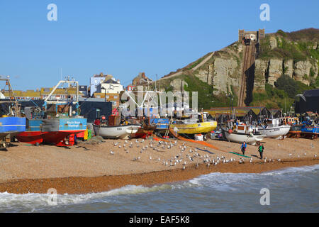 Paar zu Fuß auf Hastings Altstadt Stade Strand, vor den Fischerbooten und der Hastings Contemporary Art Gallery, East Sussex, Großbritannien. Stockfoto