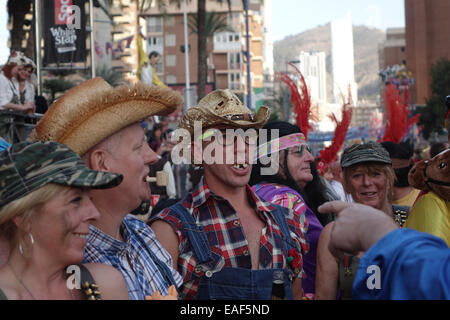 Benidorm, Costa Blanca, Spanien. 13. November 2014. Britische Feiernden verkleidet auf den Straßen von Benidorm Neustadt genießen Sie warmes sonniges Wetter. Ein einheimischer verweist auf ein Mann trägt ein Redneck oder Land Bomkin Outfit mit schlechten Zähnen. Bildnachweis: Mick Flynn/Alamy Live-Nachrichten Stockfoto