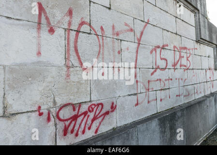 Die Graffiti an der Wand der Justizpalast in Brüssel zu sagen, "Geld ist Schuld, Schuld ist Sklaverei". Stockfoto