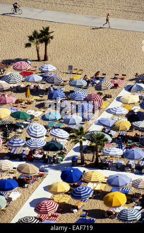 Am Strand von Santa Monica mit bunten Sonnenschirmen und Radweg Stockfoto