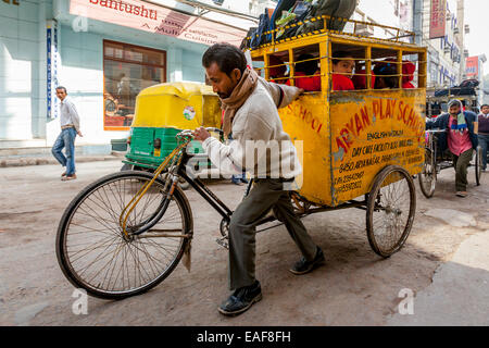 Schule Kinder zur Schule gebracht werden, per Rikscha Taxi, New Delhi, Indien Stockfoto