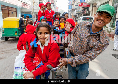 Schulmädchen ergriffen zur Schule mit dem Fahrrad Taxi, New Delhi, Indien Stockfoto