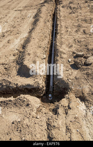 Bewässerung-System-Installation mit PVC-Rohre in Schützengräben in einem Boden-Feld Stockfoto