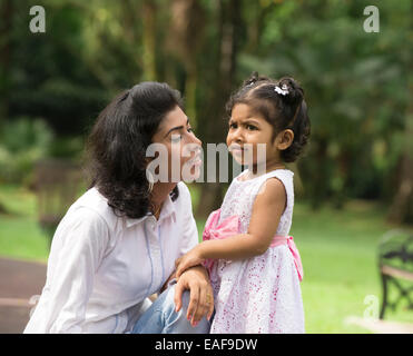 Glückliche indische Mutter und Tochter spielen im Park. Lifestyle-Bild. Stockfoto