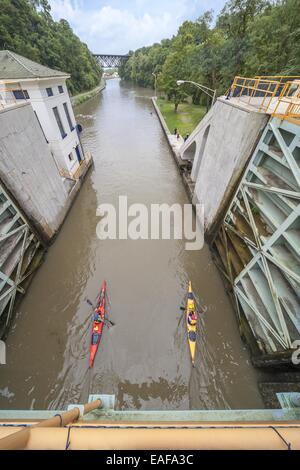 Kajak Eriekanal Lockport. Drei Kajaks paddeln aus Schloss 34 in Richtung der Upside Down Truss-Eisenbahnbrücke Stockfoto