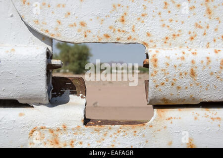 Blick durch ein Loch in den USA Grenzzaun aus Mexiko in die USA mit dem Fokus auf dem Zaun Stockfoto