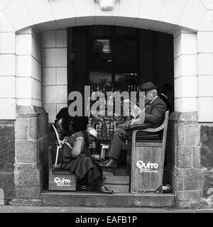 Nicht identifizierte Shoeblack Schuhputzer eines Mannes in Chile Straße im Plaza Grande (Hauptplatz) in Quito, Ecuador Stockfoto