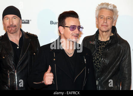 Gitarrist The Edge (L-R), Sänger Bono und Bassist Adam Clayton der irischen Rockband U2 Ankunft auf dem roten Teppich der Bambi Verleihung an das Stage Theater am Potsdamer Platz in Berlin, Deutschland, 13. November 2014.  Die Gala für die 66. Bambi-Verleihung moderiert von Hubert Burda Media fand am 13. November 2014 statt. Foto: Hubert Boesl/Dpa - NO-Draht-Dienst- Stockfoto