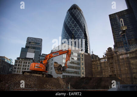 Baustelle in der City of London im Schatten der Gherkin, UK. Ein Bagger ausgräbt Boden. Stockfoto