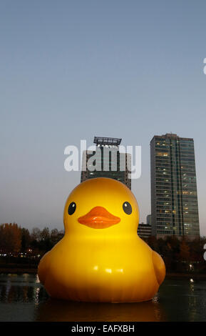 Seoul, Südkorea. 14. November 2014. Eine gigantische Gummiente, entworfen vom holländischen Künstler Florentijn Hofman sieht man schwimmt in Seokchon See, Seoul, Südkorea, auf Freitag, 14. November 2014. Die 300 kg, 54-Fuß hohen Gummiente wurde in Seoul vom 14. Oktober 2014 bis 14. November 2014 als Teil einer Werbeaktion für Lotte World Tower ausgestellt. Bildnachweis: Jone Ri/Alamy Live-Nachrichten Stockfoto